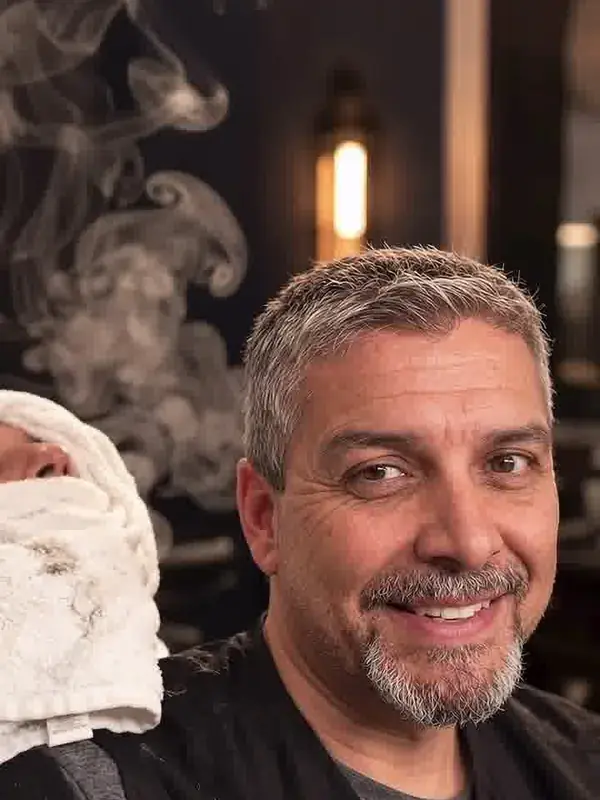 Rich Beasley, owner and barber, smiling in the shop